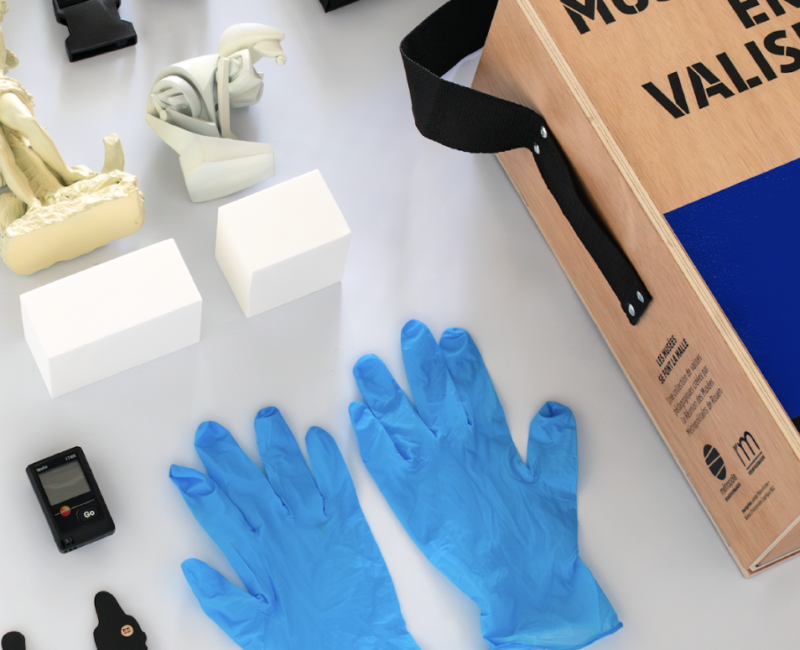 Objets présent dans le kit de découverte des musées de Rouen : des gants en plastique bleus, des figurines, des versions miniatures d'oeuvres d'art.