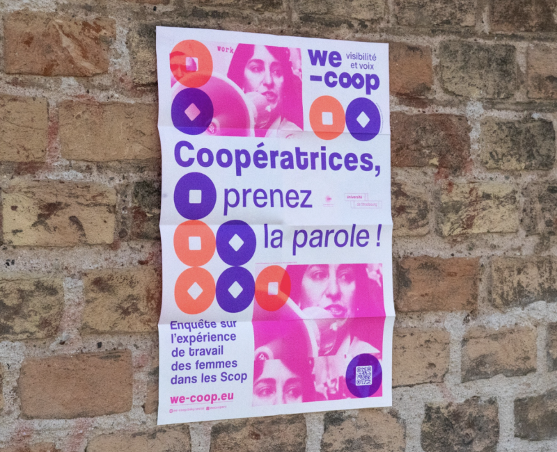 Affiche accrochée à un mur en brique. Elle est rose et composé d'une photo de femme, et d'illustration de rond et de carré.