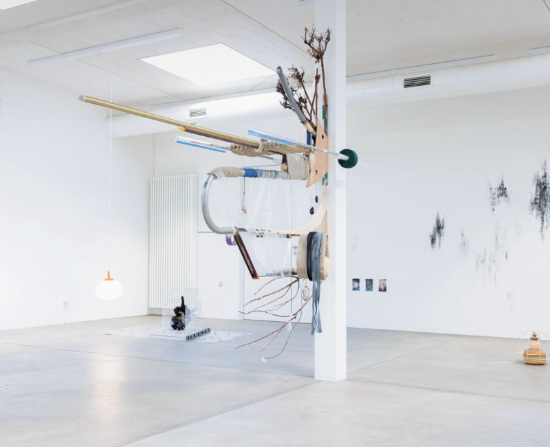 Dans une salle blanche aux murs tâchés de peinture noire, plusieurs sculptures de Vincent Gallais, à l'aspect futuristes. Accroché à une colonne la sculpture principal est composée de tuyaux, branches d'art, et d'autres matériaux de récupération.