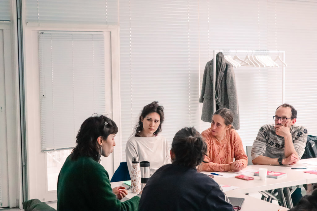 5 membres de Plan d'Est débattent autour d'une table.