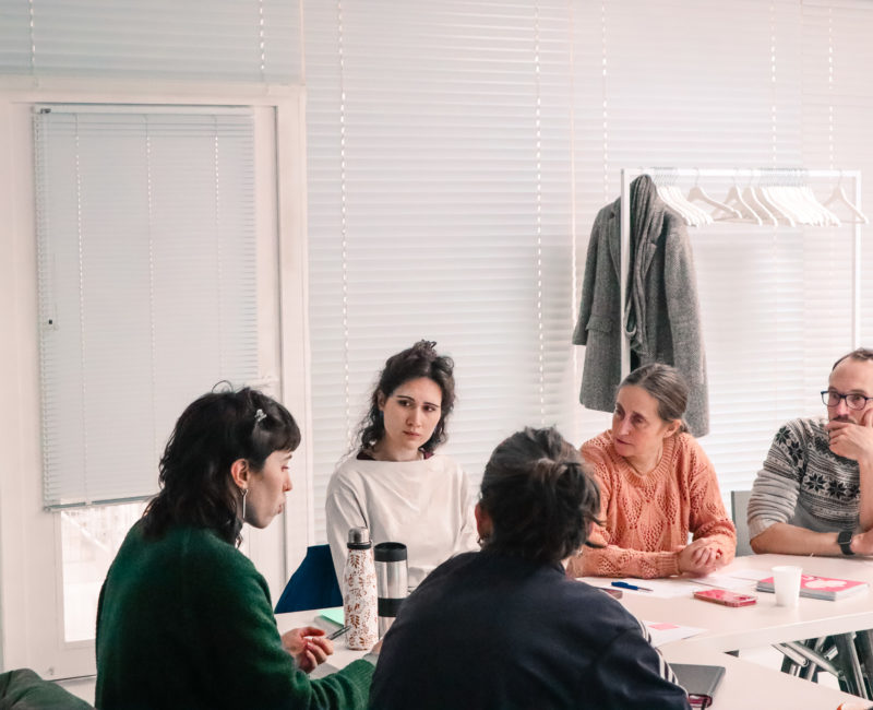 5 membres de Plan d'Est débattent autour d'une table.